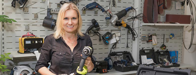 Frau in einem Veerleihshop mit Werkzeug Frau in einem Veerleihshop mit Werkzeug
